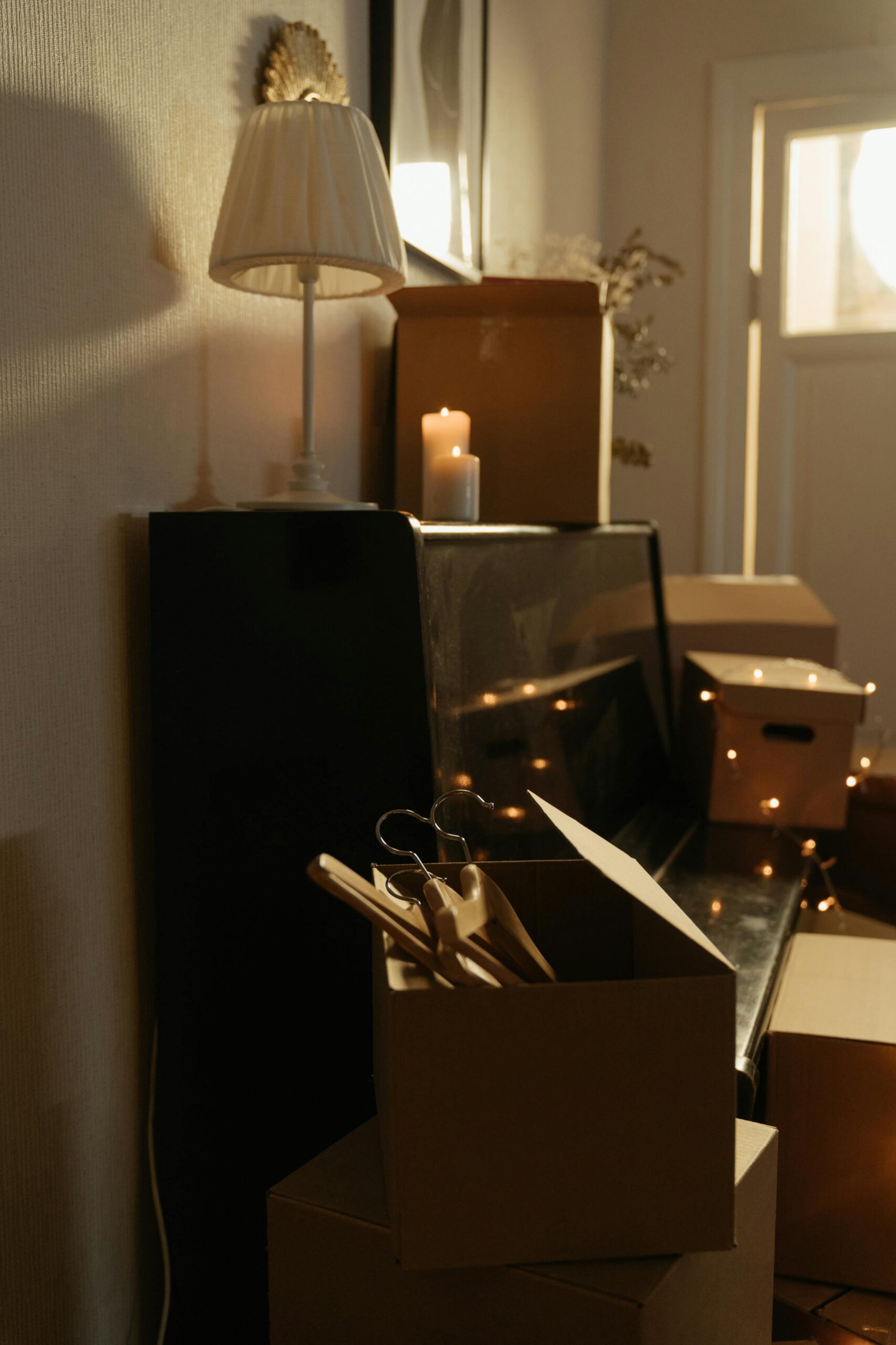 A warm and cozy room with cardboard boxes, a piano, and ambient lighting creating a peaceful atmosphere.